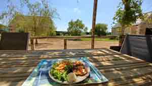 A brightly colored plate on a wooden table, on a terrace with a superb view